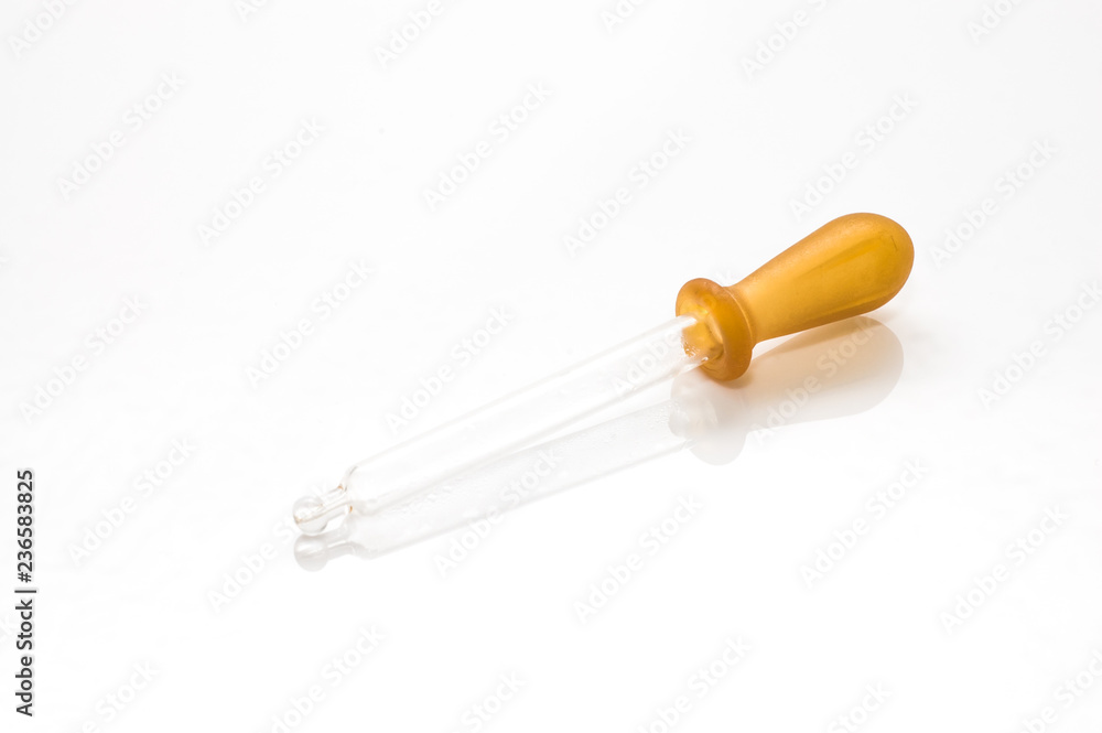 Naklejka premium Closeup of glass dropper with brown rubber isolated on white background