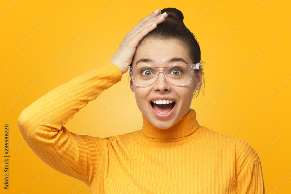 Young female shouting oh my god with open mouth, surprised by low price and sales, isolated on yellow background Young female shouting oh my god with open mouth, surprised by low price and sales, isolated on yellow background