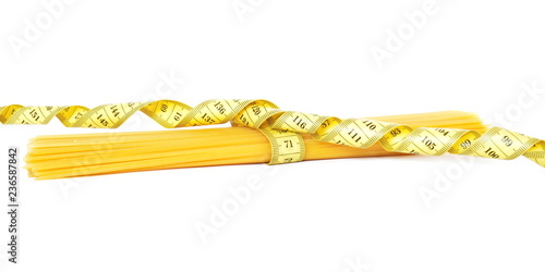 Bunch of wheat raw spaghetti tied with a spiral yellow measuring tape on white background. Side view