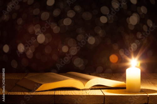 Konstfotografi a bible on the table in the light of a candle