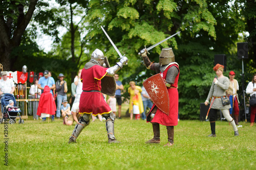 People wearing knight costumes fight during historical reenactment on annual Medieval Festival, held in Trakai Peninsular Castle.