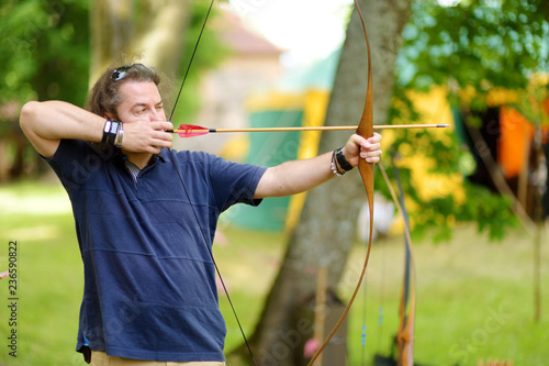 Young male shooting a bow on an annual Medieval Festival, held in Trakai Peninsular Castle.