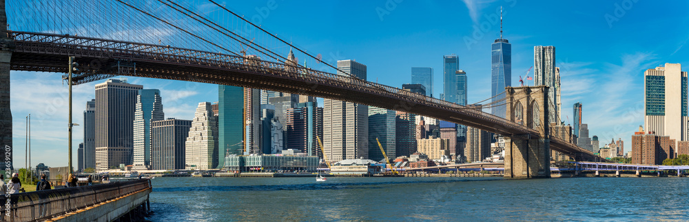 Fototapeta premium Charakterystyczny widok na Brooklyn Bridge nad Manhatten wieżowce w Nowym Jorku.