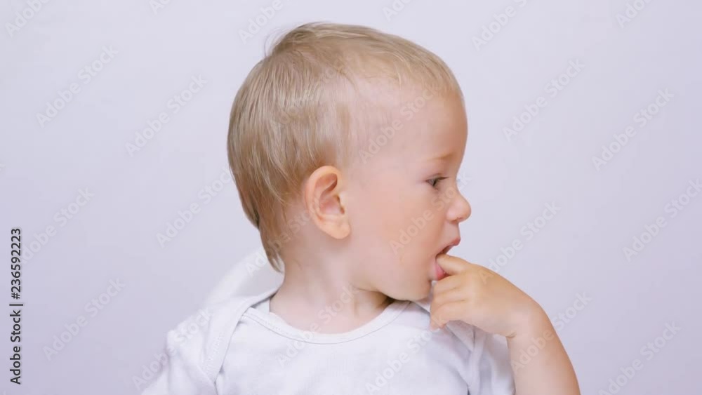 Baby child portrait moving hands, boy put fingers in his mouth Baby child portrait moving hands, boy put fingers in his mouth