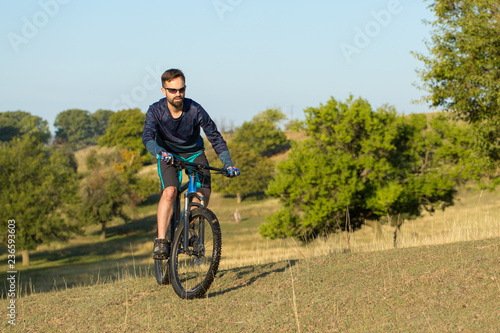 Fototapeta Naklejka Na Ścianę i Meble -  Cyclist in shorts and jersey on a modern carbon hardtail bike with an air suspension fork