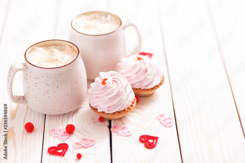 Two cups of coffee and cupcakes with pink cream for Valentine's Day or Birthday, wedding day. White wooden background. Selective focus