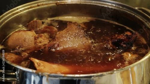 Cooking demi-glace -  rich brown sauce,  French cuisine, used by itself or as a base for other sauces.  Making basic brown stock from beef or veal bones, Closeup.