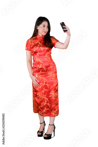 Woman takes photo with cheongsam dress © Creativa Images