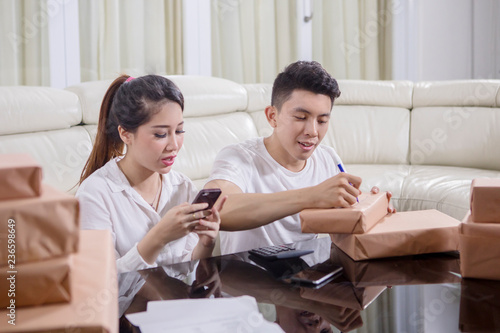 Young couple doing online business by phone