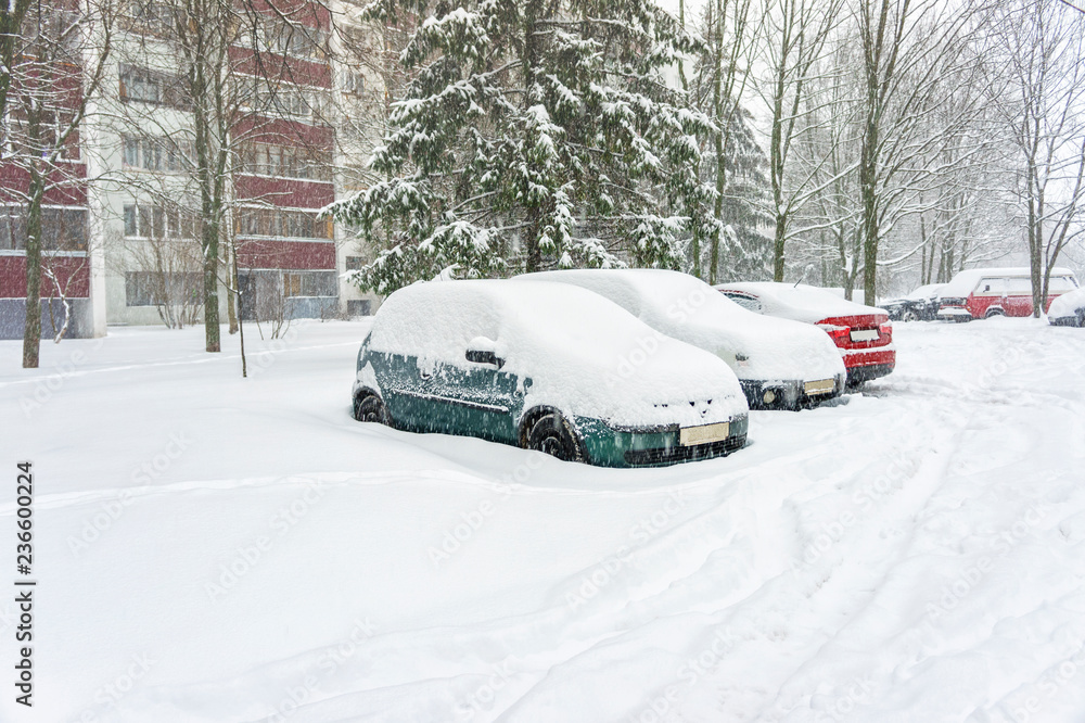 Three cars in the parking lot are covered with a thick layer of snow. Large precipitation concept Three cars in the parking lot are covered with a thick layer of snow. Large precipitation concept