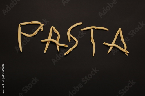 Pasta. scrittura su sfondo nero scritta con la pasta fresca