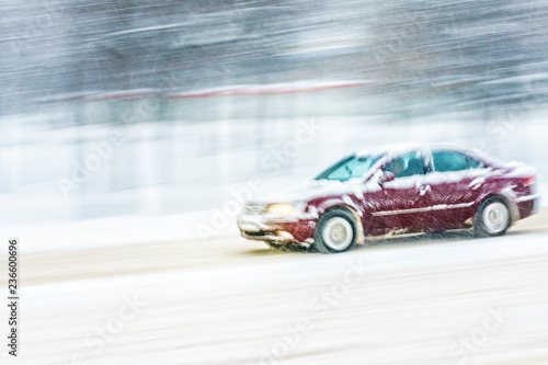 Driving in snow. Motion in blur car in heavy snowfall in city road. Abstract blur winter weather background