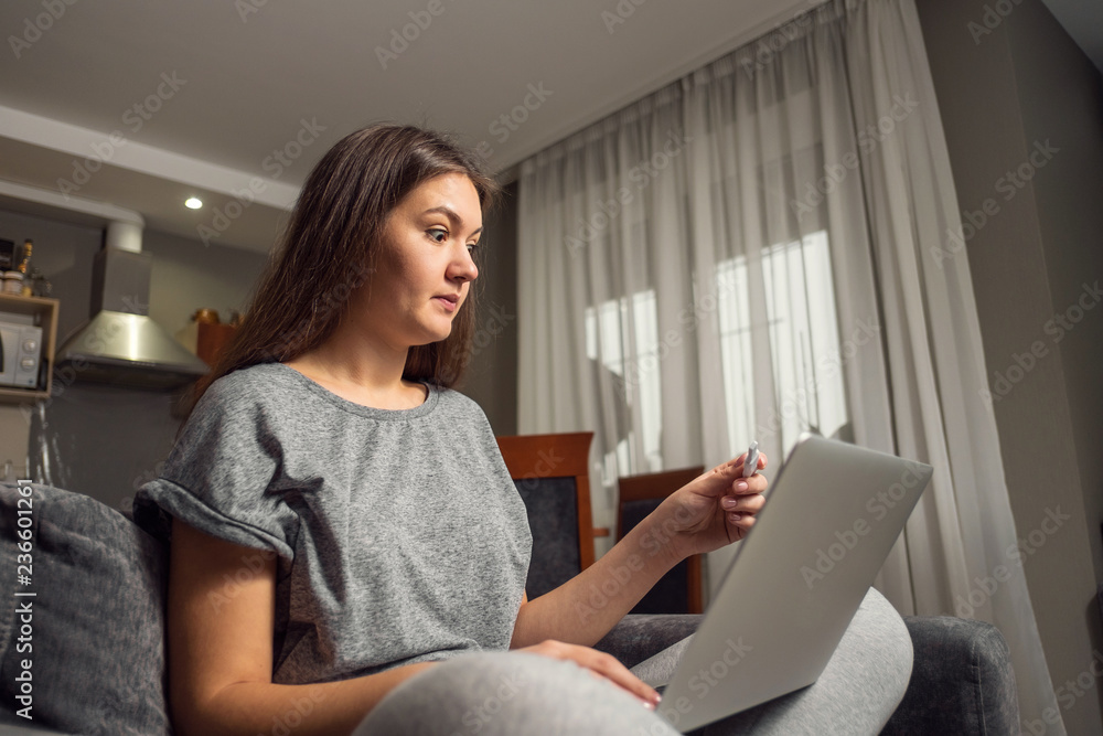 surprised young woman and pregnancy test with laptop, woman looking for information about pregnancy on Internet with laptop surprised young woman and pregnancy test with laptop, woman looking for information about pregnancy on Internet with laptop