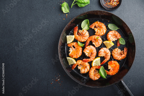 Fried fresh shrimps with spices on black pan