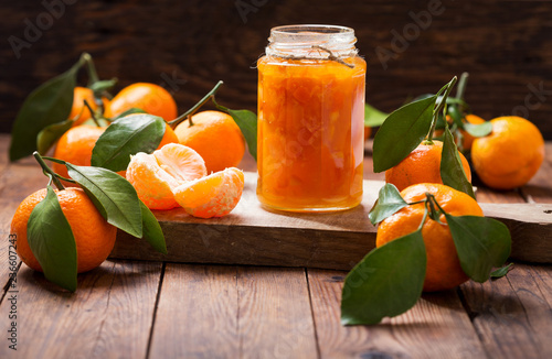 glass jar of tangerine jam with fresh fruits