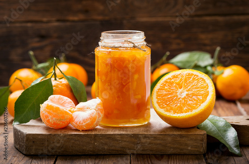 glass jar of orange tangerine jam with fresh fruits