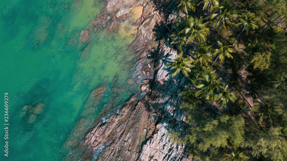 Aerial drone top view of the amazing rocky and green coast on the tropical island Aerial drone top view of the amazing rocky and green coast on the tropical island