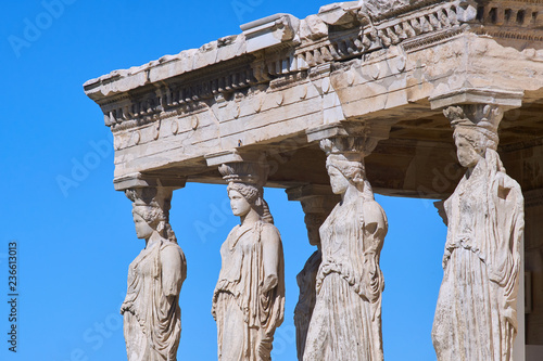 ATHENS, GREECE - 03.15.2018: Caryatides Replica Figures On The Caryatid Porch Of The Erechtheion Temple By The Acropolis Against A Blue Cloudless Sky.