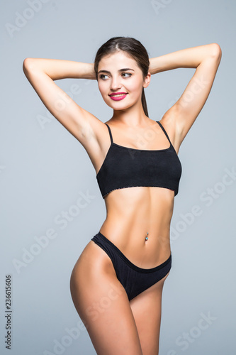 Fitness perfect woman with a beautiful body in black lingerie isolated on gray background