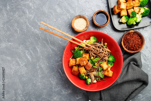 Bilde på lerret Soba noodles with vegetables and fried tofu in a bowl. Top view.