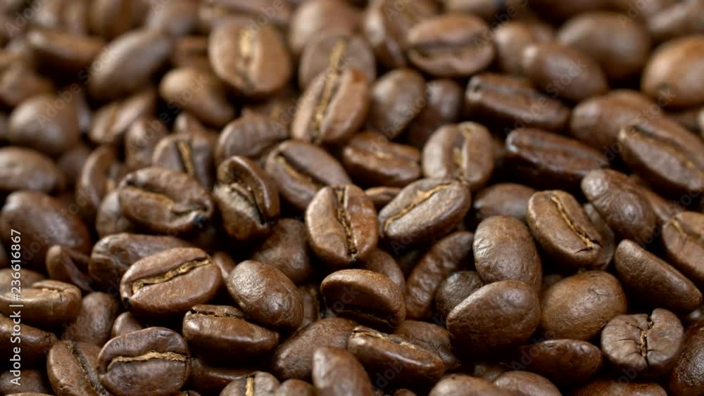 Coffee beans background. Close up shot of rotating roasted coffee beans. 4K, UHD Coffee beans background. Close up shot of rotating roasted coffee beans. 4K, UHD