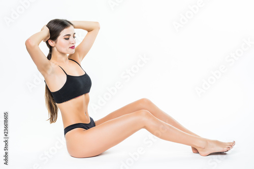 Studio shot of sexy young woman in lingerie posing lying on the floow. Fit young woman with muscular body. Slim and fit female model.