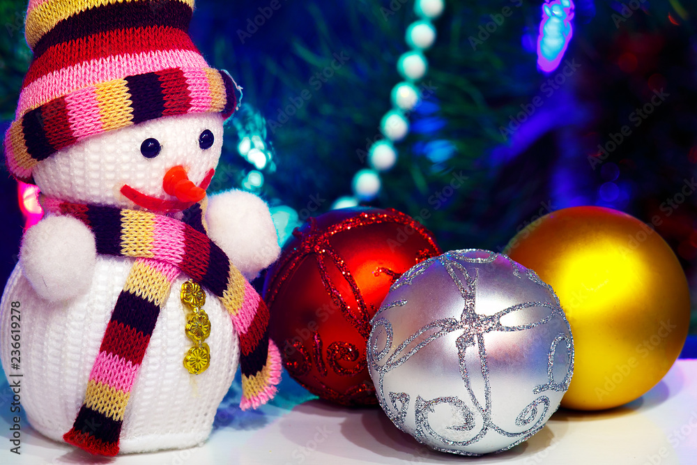 Toy snowman on the background with three Christmas balls