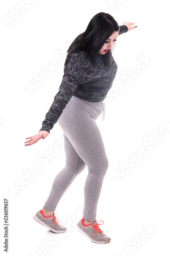 plus size model in sporty form walks over socks on an imagined rope isolated on white background