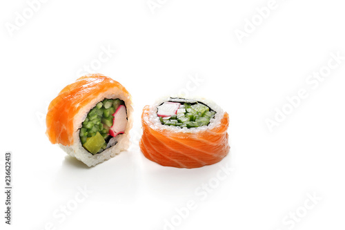 Maki, sushi z łososiem paluszkiem krabowym, ogórkiem i awokado.  Rolka sushi na białym tle.