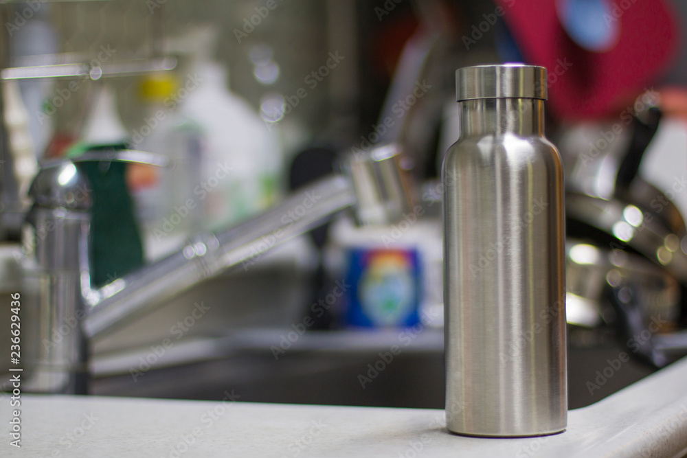 Insulated Stainless Bottle with utensils and sink kitchen background Insulated Stainless Bottle with utensils and sink kitchen background