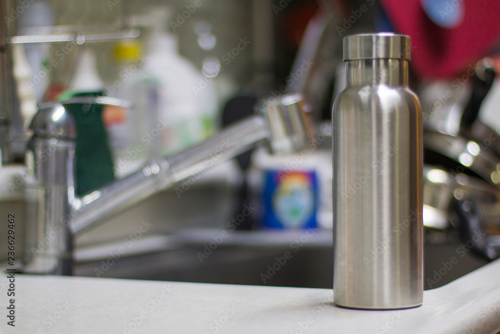 Insulated Stainless Bottle with utensils and sink kitchen background Insulated Stainless Bottle with utensils and sink kitchen background