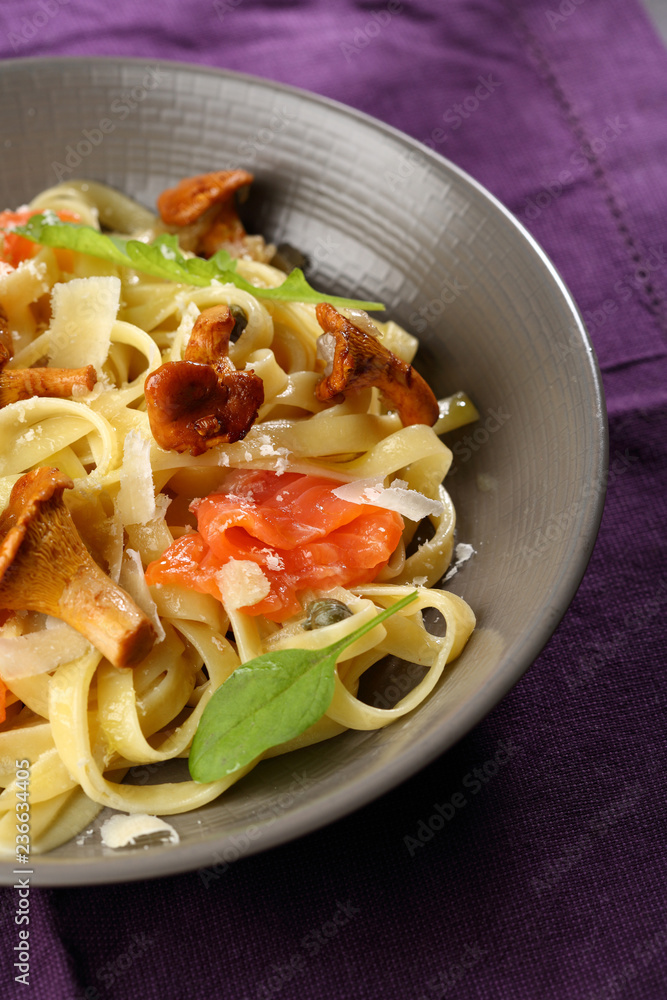 Tasty pasta with salted salmon and chanterelles mushrooms Tasty pasta with salted salmon and chanterelles mushrooms