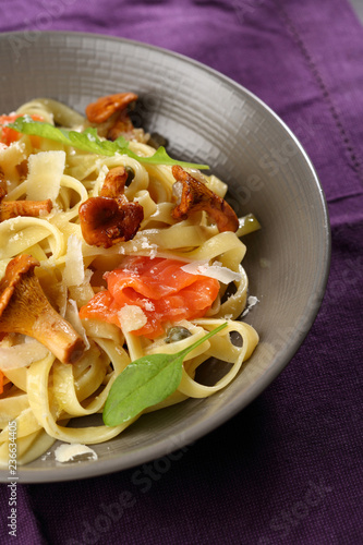 Tasty pasta with salted salmon and chanterelles mushrooms