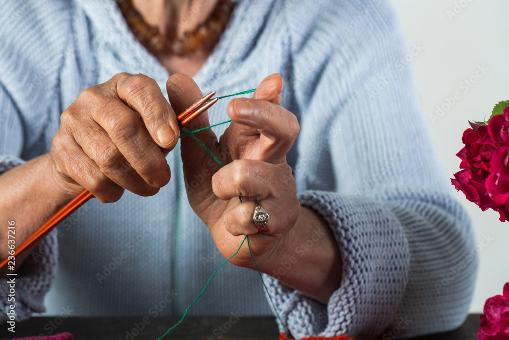 Foto Stock Old lady with wrinkled hands do knitting. Hobby and hand