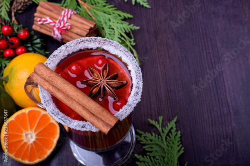 Hot mulled wine with slices of citrus fruits, cinnamon and anise in an Irish glass decorated with sugar border. Copy space