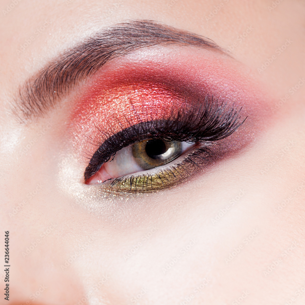 Obraz premium Amazing Bright eye makeup in luxurious scarlet shades. Pink and blue color, colored eyeshadow