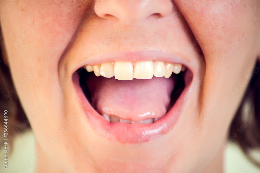 Obraz premium Beautiful young woman with healthy teeth on white background. Close up shot