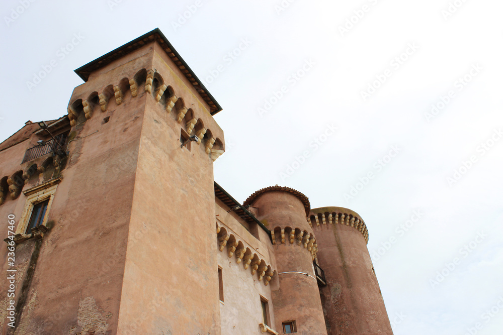 the towers of the castle of Santa Severa stand out in the cloudy white sky on a cold winter day. In Lazio, Italy, Rome