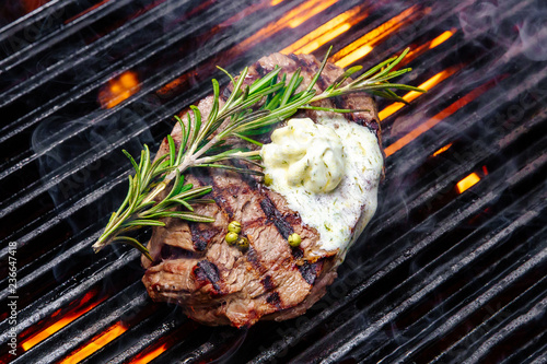 steak on a grill fire, with herbs and butter photo