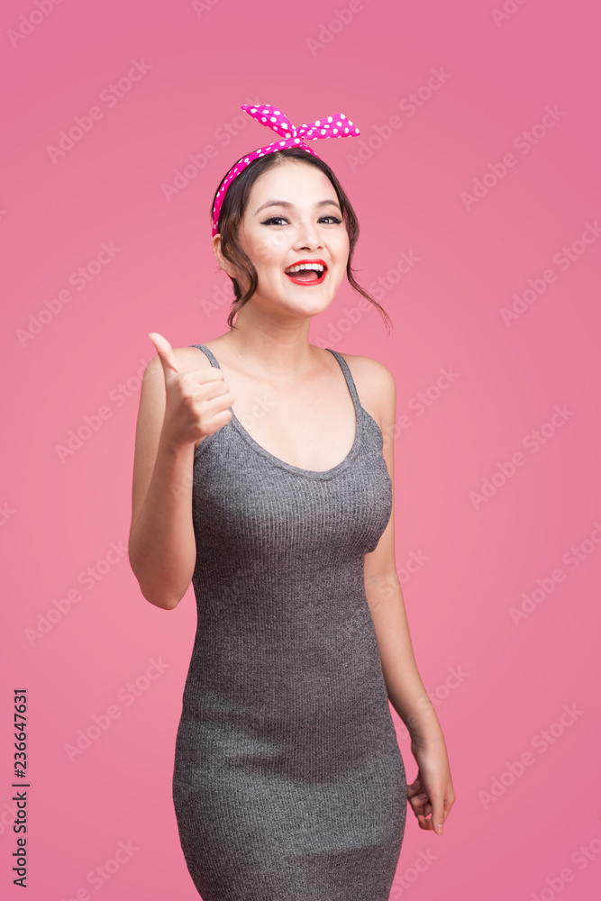 Portrait of asian girl with pretty smile in pinup style with hands gesture on pink background Portrait of asian girl with pretty smile in pinup style with hands gesture on pink background