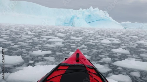 kayaking in Antarctica, red canoe boat  moving through the ice