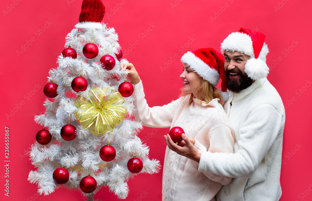 Happy Girlfriend Decorating Christmas Tree At Home With Boyfriend Family In Santa Hats Love X Mas Winter Holiday Husband And Wife Celebrate New Year Stock Photo - A Family By Decorating Christmas Tree At Home