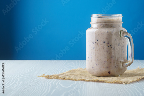 Blueberry raspberry smoothie on a blue background