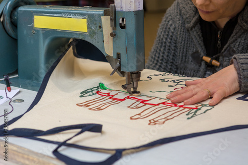 Person using sewing machine to draw a image onto fabric. photo