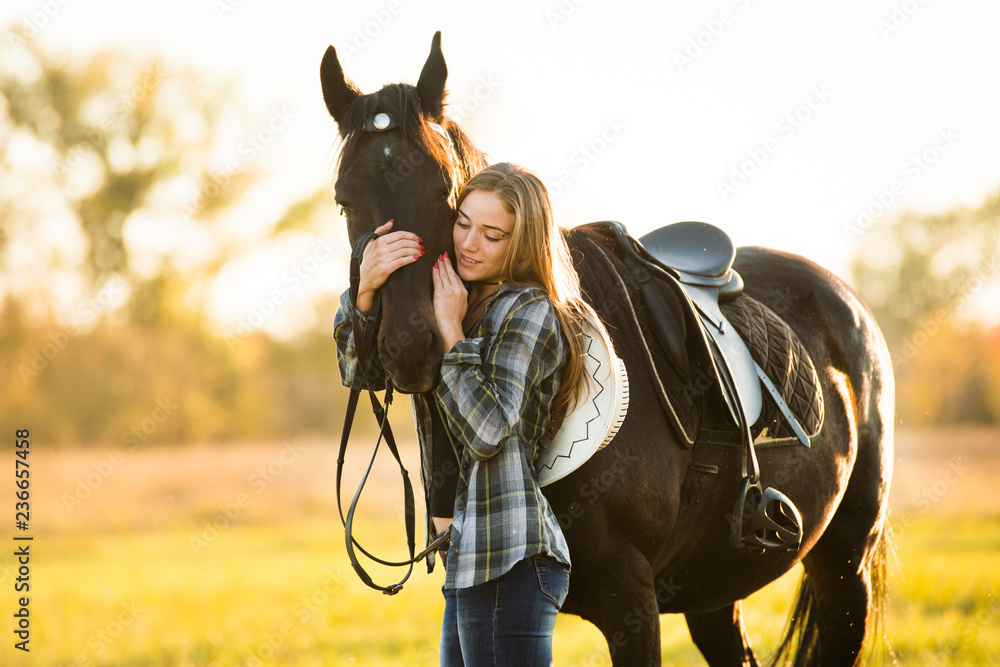Obraz premium Girl equestrian rider stands near the horse. Horse farm. Horse theme 