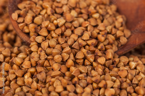 Group of buckwheat groats in a wooden spoon, healthy food
