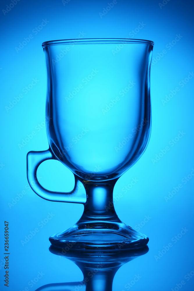 Transparent cup on blue background