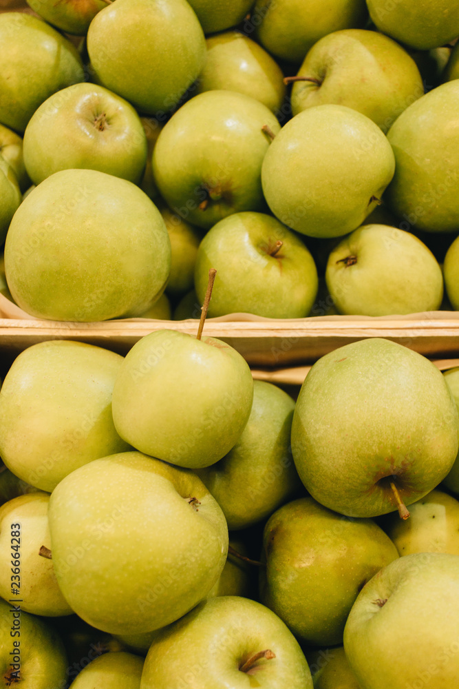 Pile of fresh ripe green apples in boxes at market