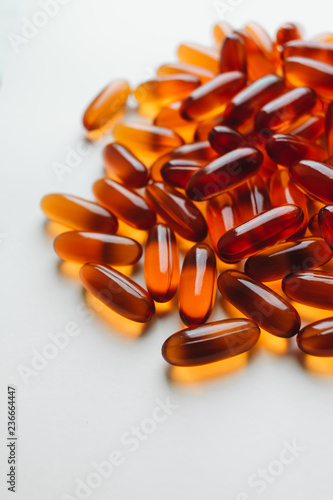 Pile of scattered capsules with medication on white background
