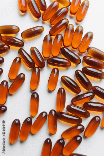 Pile of scattered capsules with medication on white background